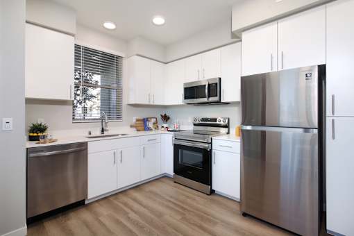 A modern kitchen with stainless steel appliances and white cabinets.