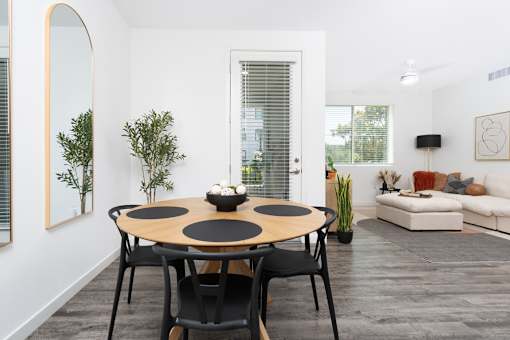 A modern dining room with a round table and chairs.