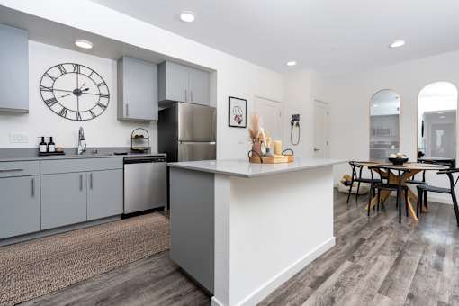 A modern kitchen with a large island and a dining table.