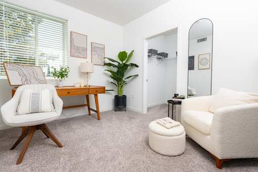 A living room with a chair, a couch, a table, and a plant.