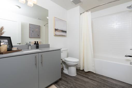 A white bathroom with a toilet, sink, and bathtub.