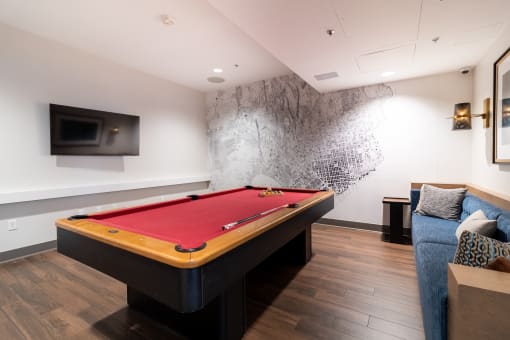 a billiards table in a living room with a red pool table at Strata at Mission Bay, California