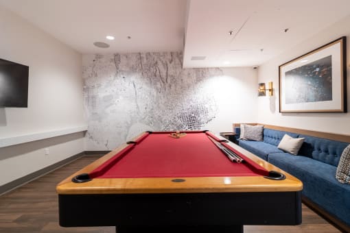 a games room with a pool table and a blue couch