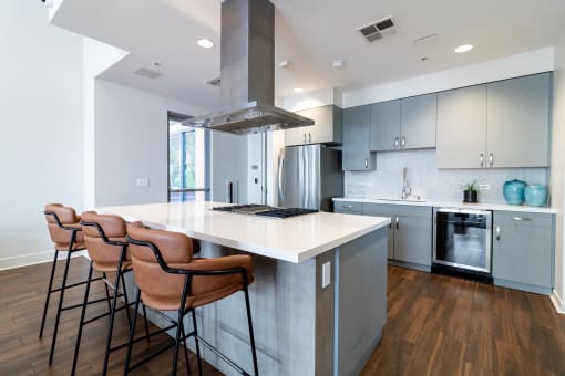 a kitchen with a large island with four stools in front of it at Strata at Mission Bay, San Francisco, California