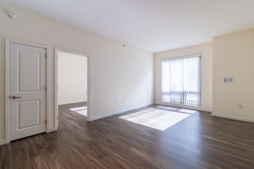 an empty living room with wood flooring and a window at Strata at Mission Bay, San Francisco, CA, 94158