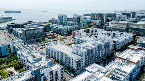 A cityscape with buildings and a body of water in the background.