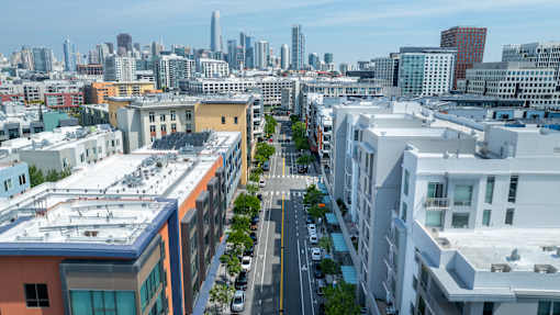 A cityscape with buildings and cars on the street.