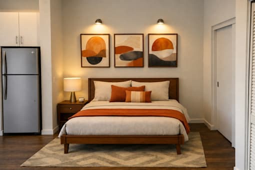 A bedroom with a bed, nightstand, and two wall art pieces.
