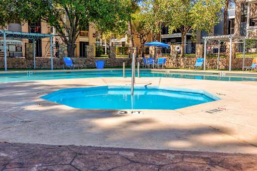 A round blue pool with a fountain in the middle.