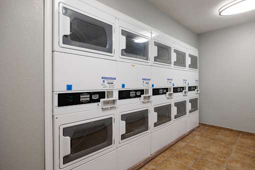 A row of white ovens are lined up in a room.
