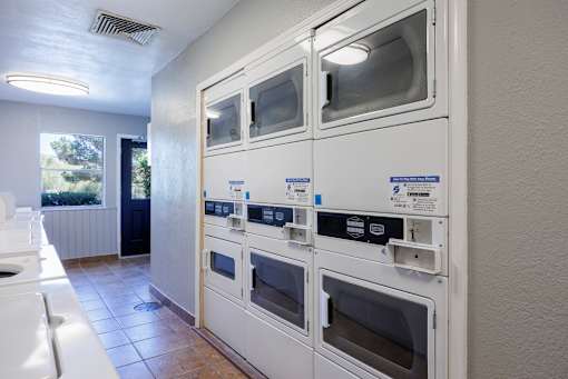 A row of white ovens are lined up in a kitchen.