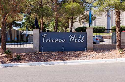 A sign that says Terrace Hill stands in front of a building.