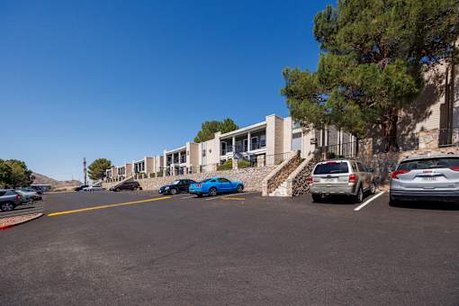 A parking lot with cars and a building in the background.