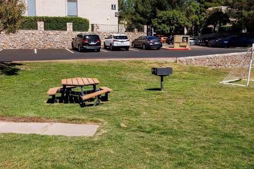 A park with a bench and a soccer goal.