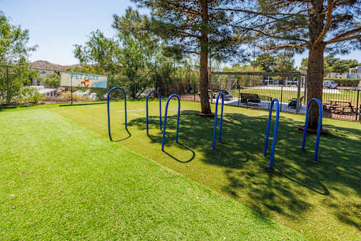A park with a grassy area and exercise equipment.
