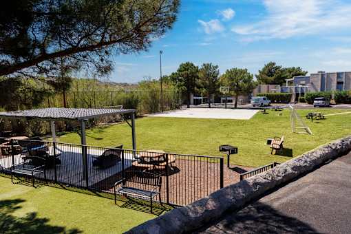 A park with a playground and picnic tables.