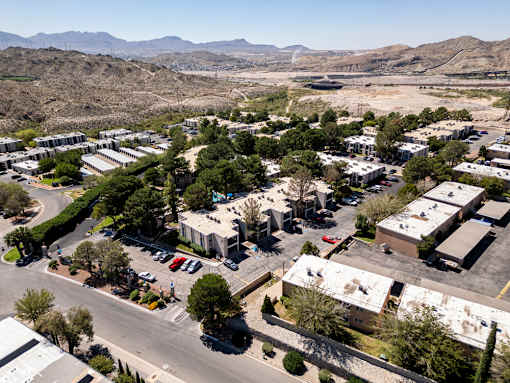 A view of a parking lot with cars and buildings.