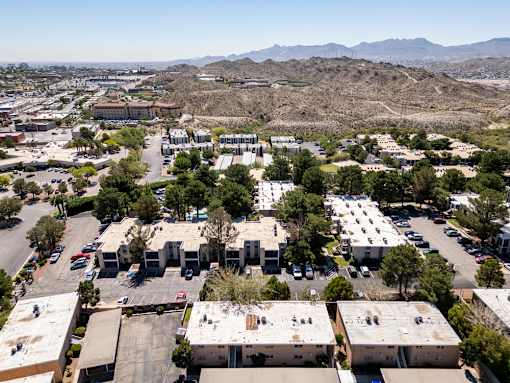 A large parking lot with several buildings in the background.