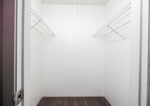 Empty refrigerator with shelves and a mat on the floor.