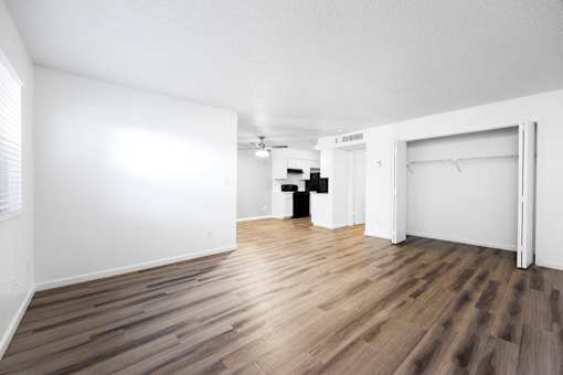 A room with wooden flooring and white walls.