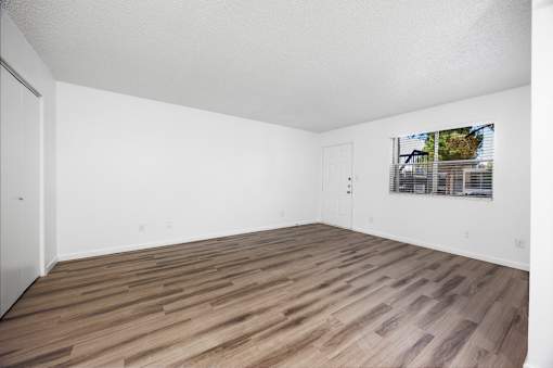 A room with wooden flooring and white walls.