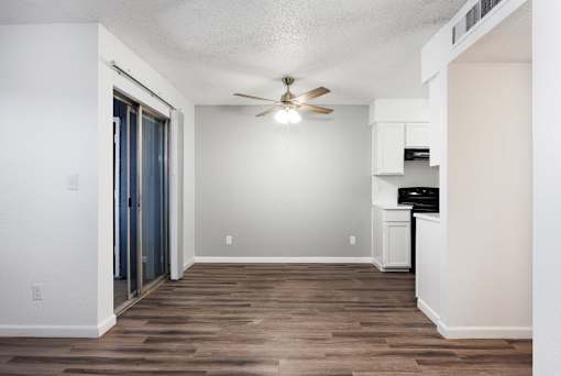 A room with a ceiling fan and a wooden floor.