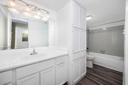 A white bathroom with a sink, toilet, and bathtub.