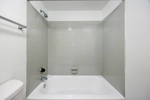 A white bathroom with a white tub and toilet.
