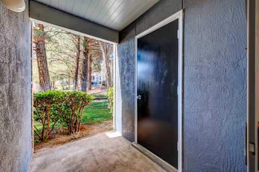 A patio with a door leading to a backyard.