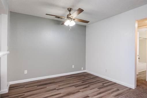 A room with a ceiling fan and light fixture.