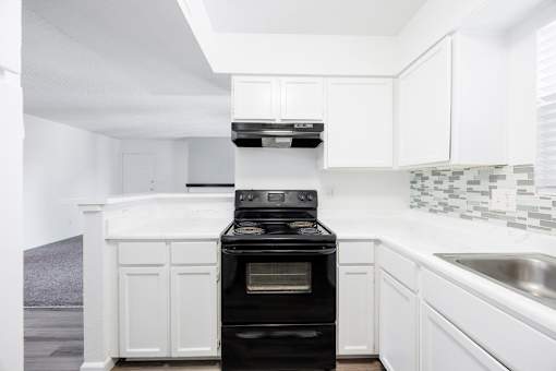 A black oven in a white kitchen.