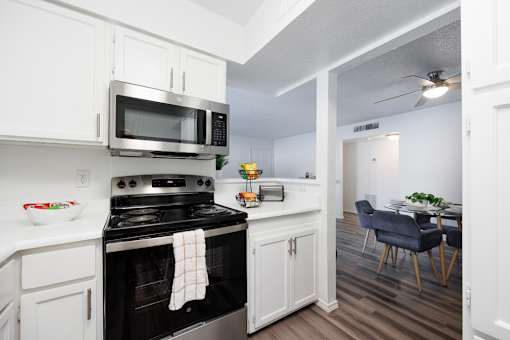 A kitchen with a stove, microwave, and oven.