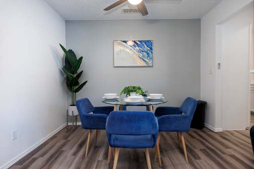 A dining room with a table and blue chairs.