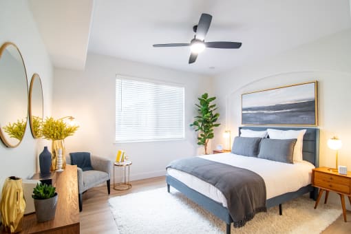 One-Bedroom Apartments in Broomfield, CO - Terracina - Bedroom with Ceiling Fan, Blue Bedroom Headboard, and Double Nightstands