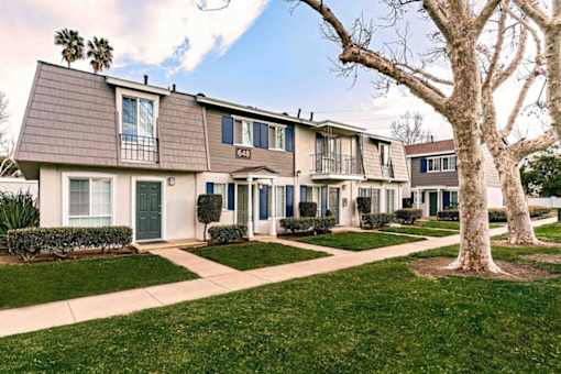 A row of houses with a tree in front of them at Nola 624 Apartments, West Covina