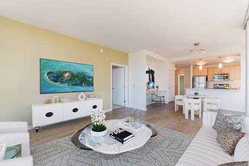 A living room with a white sofa and a coffee table with a book on it at The Grand Apartments, California