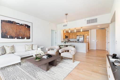 A living room with a white couch and a brown coffee table at The Grand Apartments, Oakland