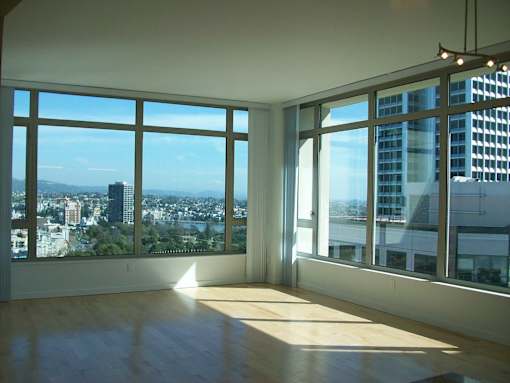 A room with a view of the cityscape. with large windows at The Grand Apartments, Oakland, CA, 94612