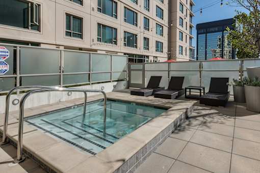 A small pool with a metal railing and a glass wall behind it at The Grand Apartments, Oakland, CA