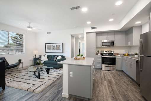 A modern kitchen with a dining area and a living room.