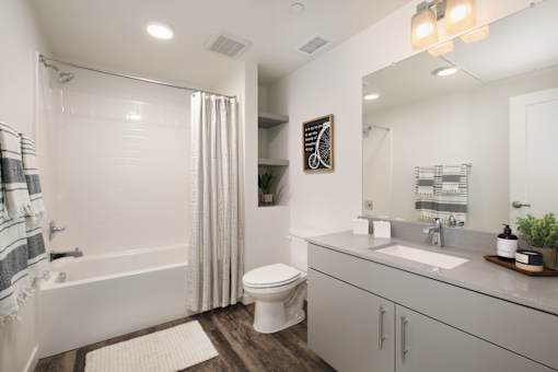 A white bathroom with a toilet, sink, and shower.