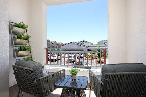 A patio with a table and chairs overlooking a street.