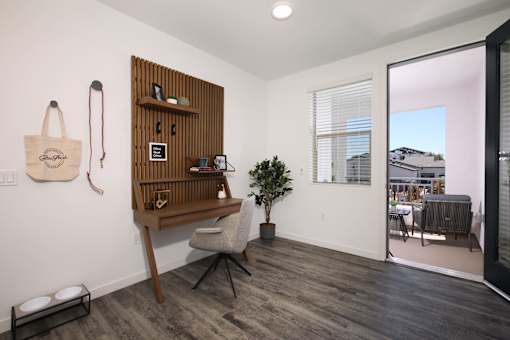A room with a chair and a shelf with a plant on it.