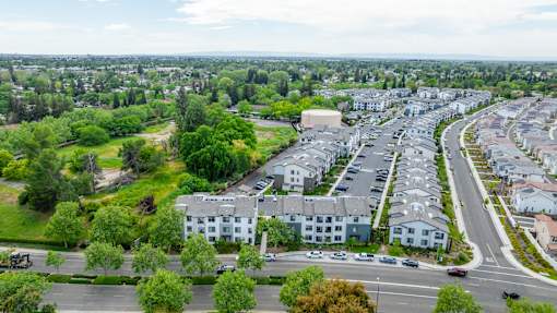 A suburban area with apartment buildings and a parking lot.