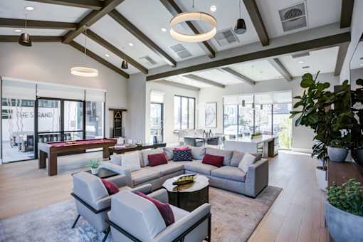 Clubroom with a large grey sofa and a wooden coffee table.