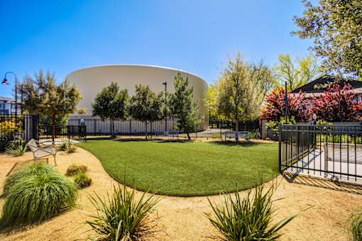 A large white dome-like structure is surrounded by a fence and greenery.