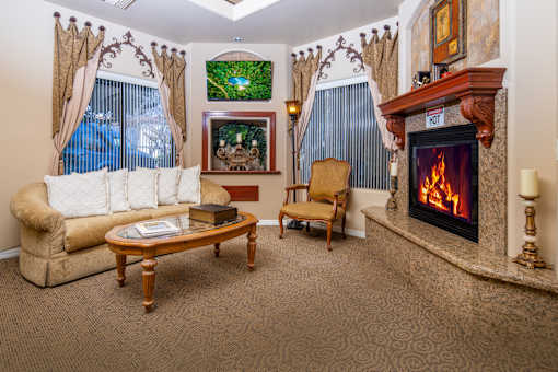 A living room with a fireplace and a painting on the wall.