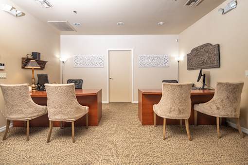 A room with a desk and chairs.