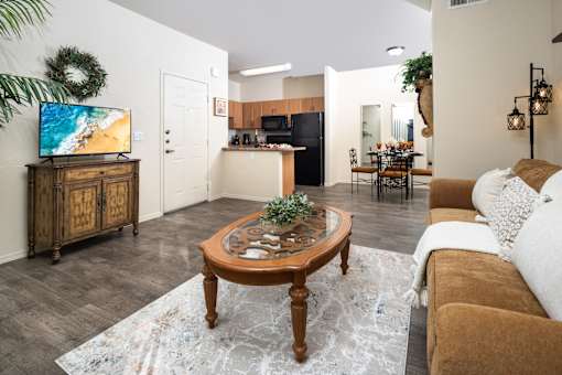 A living room with a brown coffee table and a white couch.