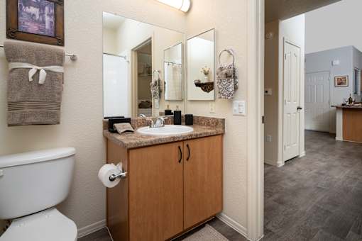 A bathroom with a toilet, sink, and mirror.
